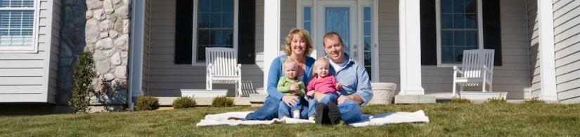 Family of four relaxing on a lawn after treatment by a Mequon pest control company